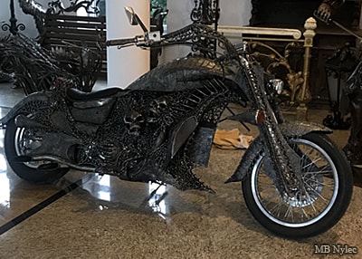 Custom chopper motorcycle covered in steel sculpture with skulls and creatures