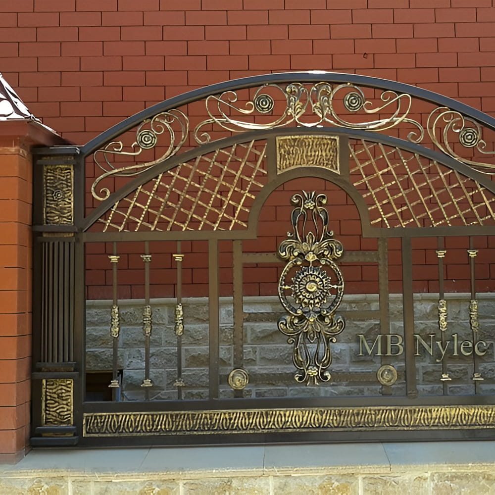Arched forged fence panel BP229 with diamond lattice, gilded scrolls and a central rosette between brick pillars