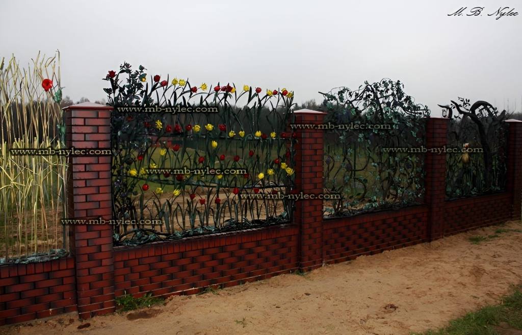 Botanical forged fence BM26 with different flower spans along a brick wall
