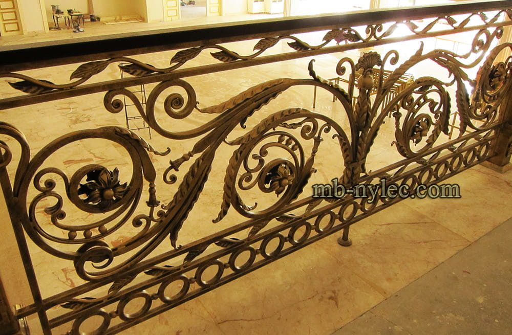 Interior stair railing BA63 with forged leaves, spirals and a band of rings in a brass finish