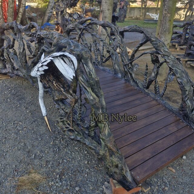 Bridge railing with a white steel heron resting on it