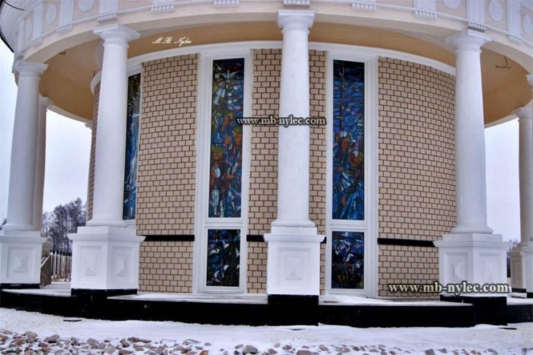 White chapel rotunda with columns and tall stained glass windows in winter