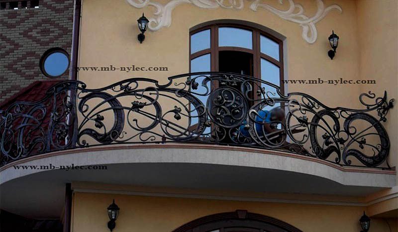 Hand-forged balcony railing BA46 with large loops, leaves and a central rosette on a curved balcony