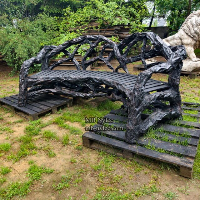 Curved garden bench with forged branches seen from the side