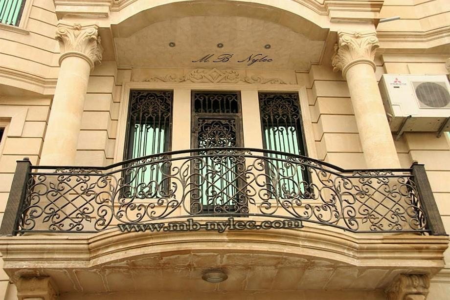 Forged railing BA36 with lattice and scrolls on a curved carved-stone balcony between columns
