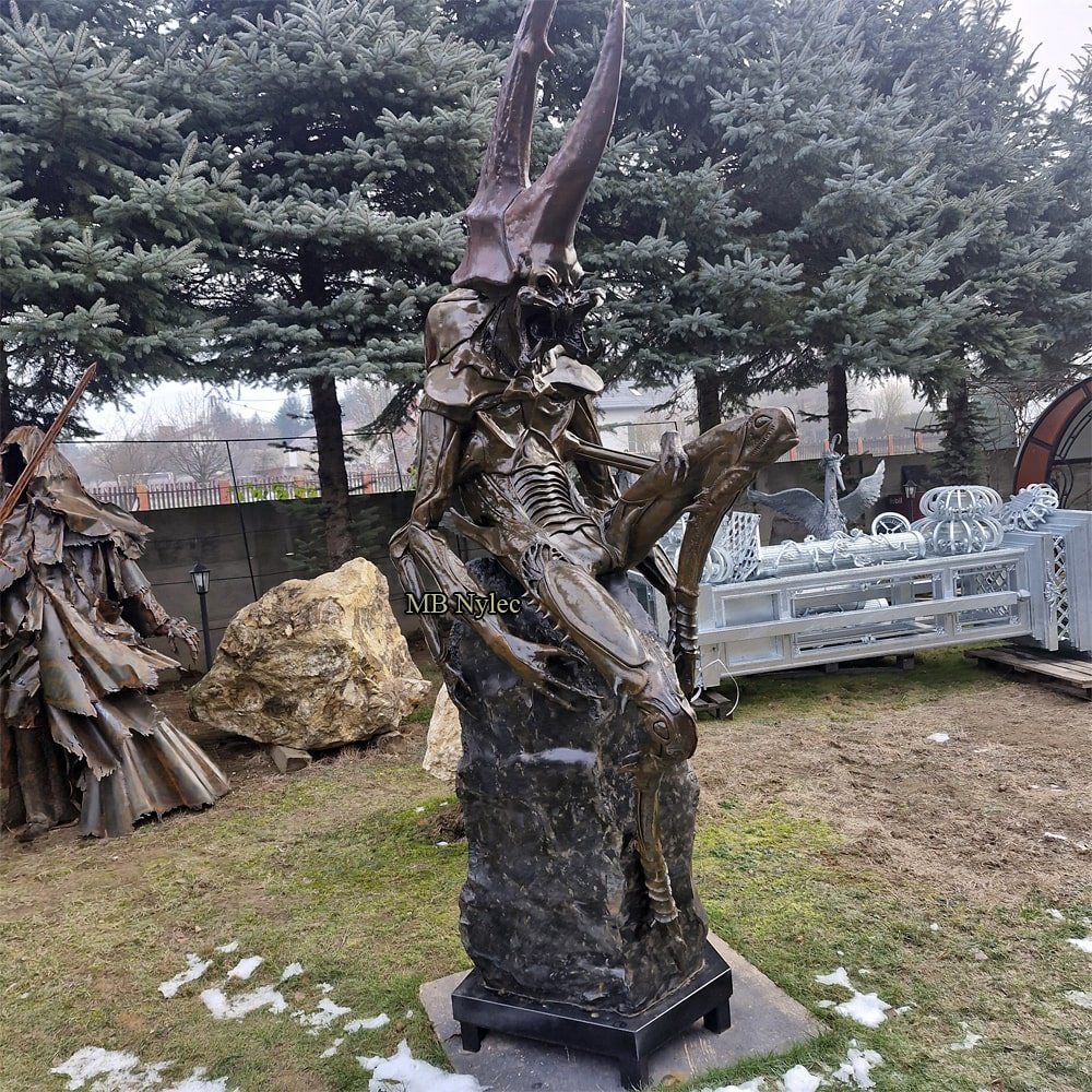 Giant steel demon bug sculpture on a polished basalt block