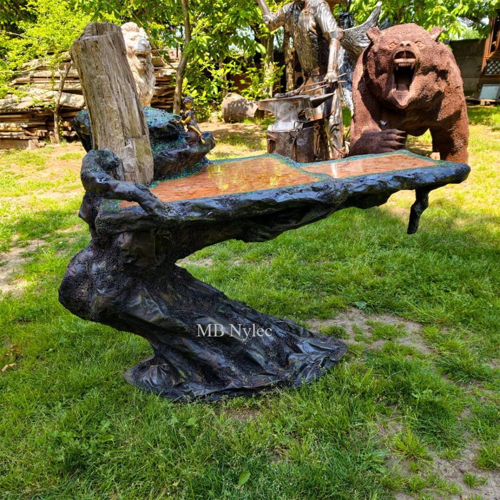 Designer coffee table standing in a garden next to sculptures