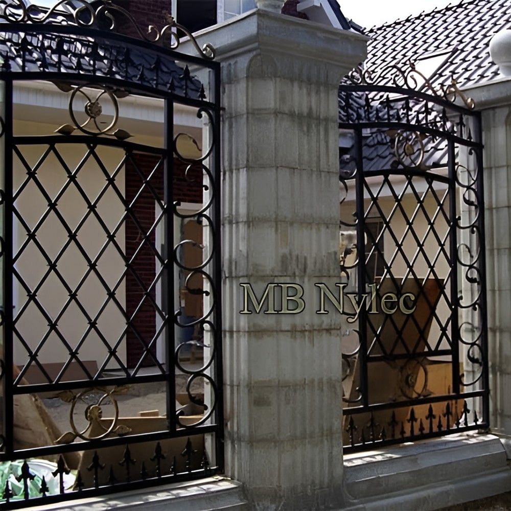 Forged fence BP218 with diamond lattice and a scrolled top band beside a stone pillar