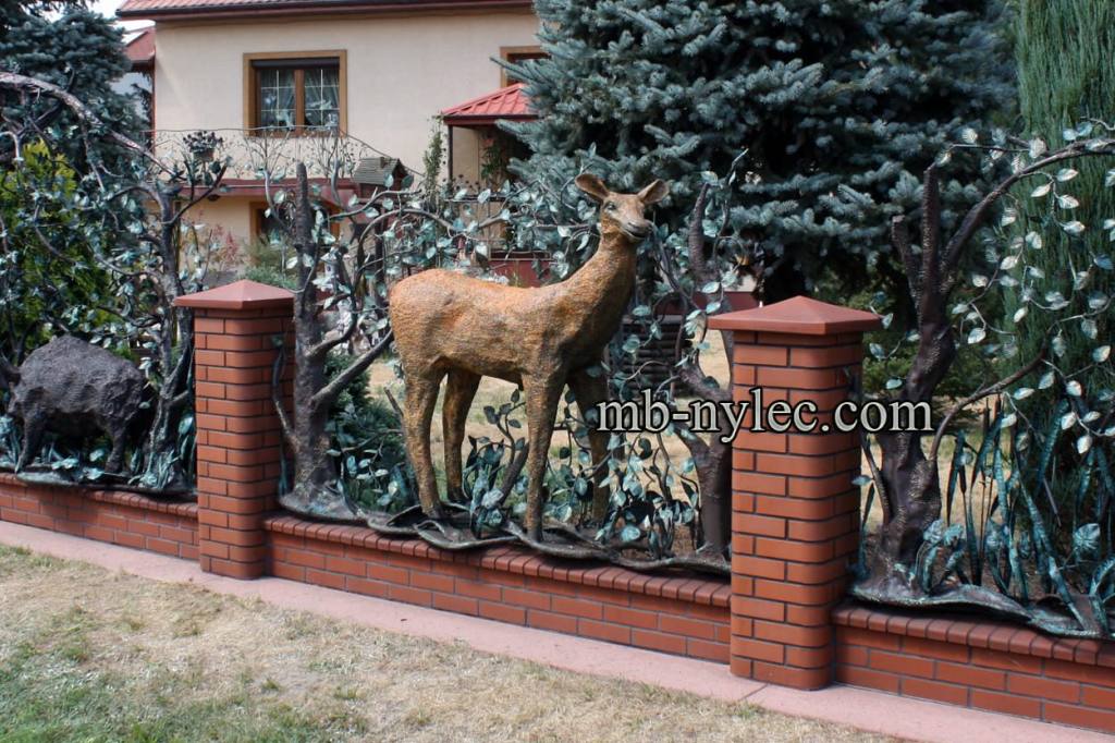 Fence BM22 with a forged doe between brick pillars in front of a house