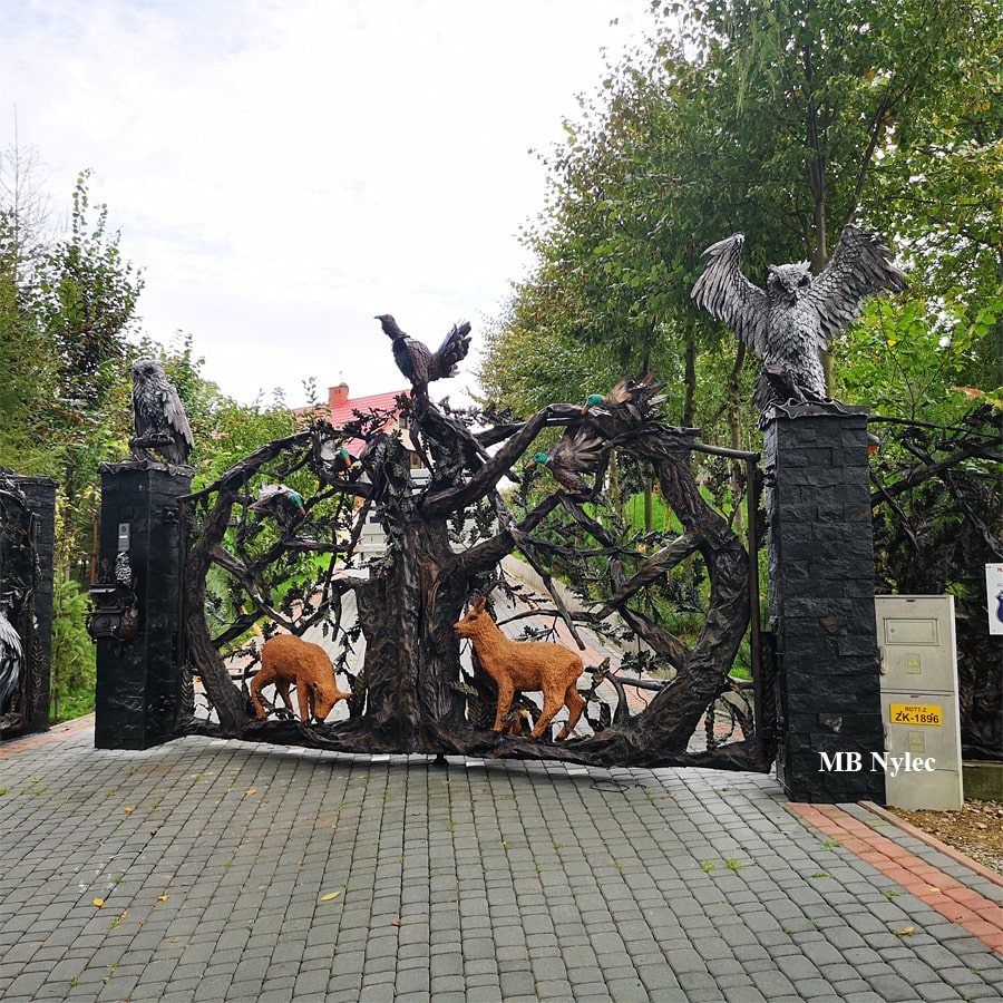 Double metal driveway gate with steel owls on the pillars