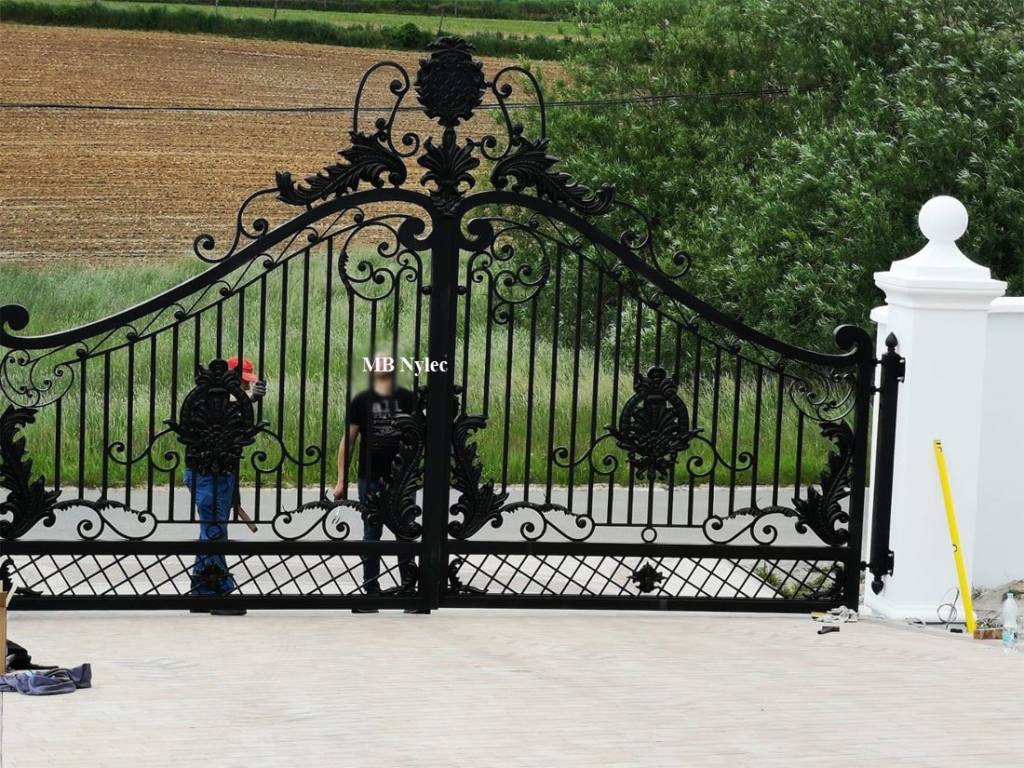 Double swing metal gate with two people for scale