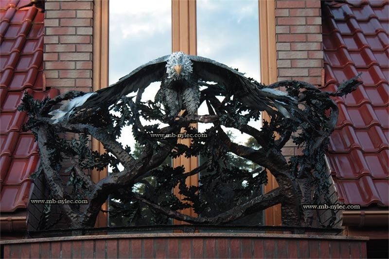 Front view of eagle balcony railing BA40 in front of a window and red tiled roof