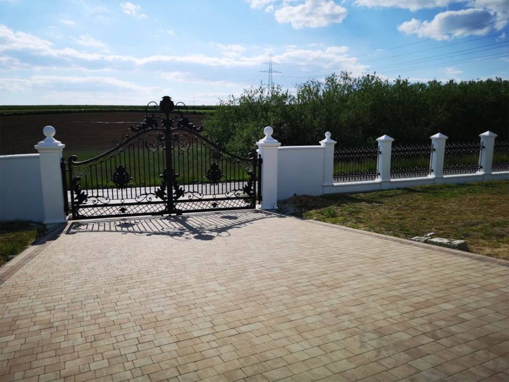 Entrance gate and matching fence on a long white wall