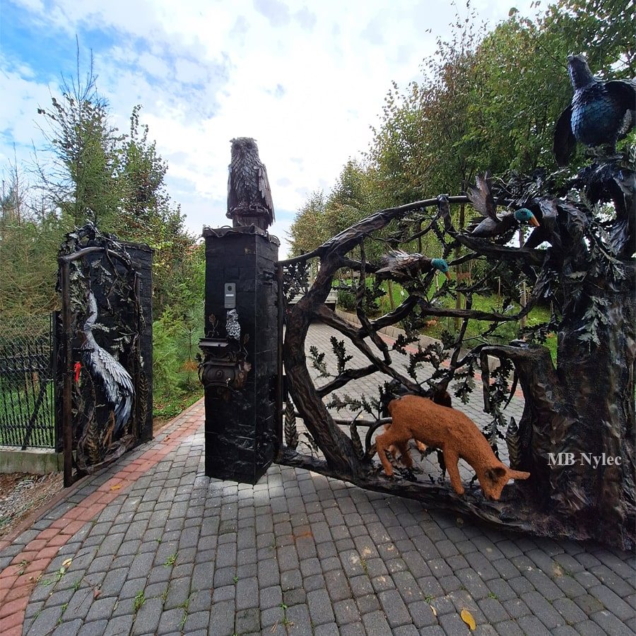 Entrance gate with an owl and a fox sculpture