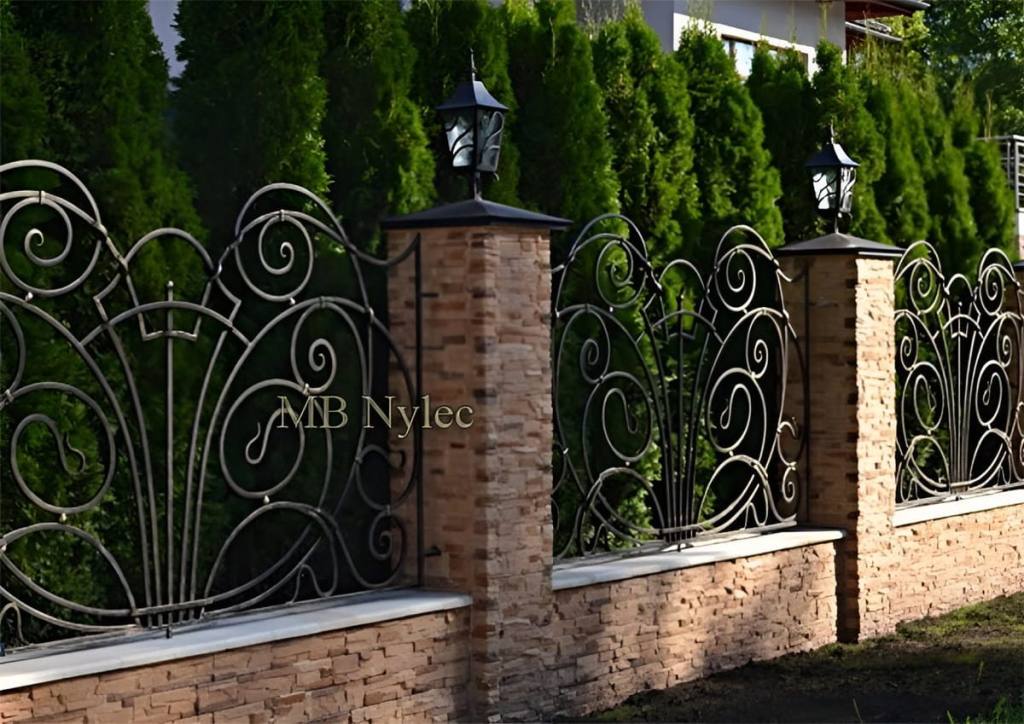 Forged fence BP252 with fan-shaped scrolls between stone-clad pillars topped with lanterns
