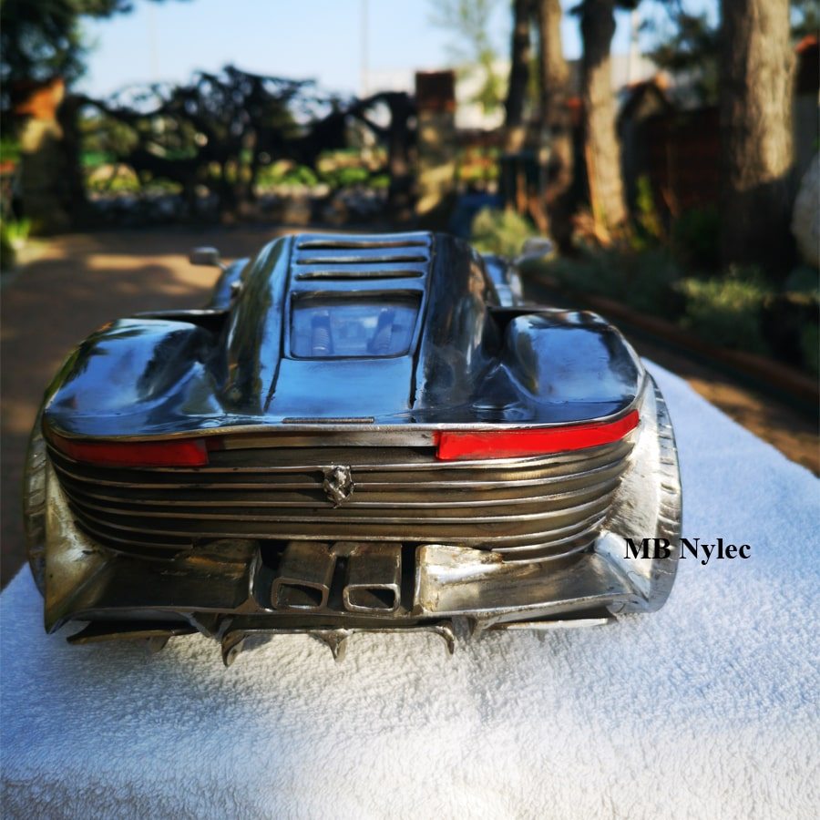 Ferrari SP3 metal sculpture with the engine visible through the rear window
