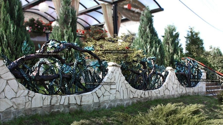 Forest fence BM33 with forged oak branches and ferns above a stone wall