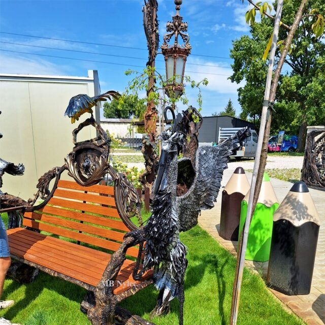Forged bench with birds perched along the crest