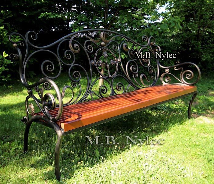Forged bench MK1 standing on grass in the shade of trees