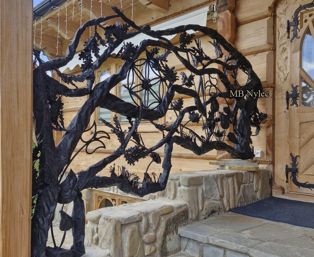 Forged branch balustrade with highland rosettes beside a log wall