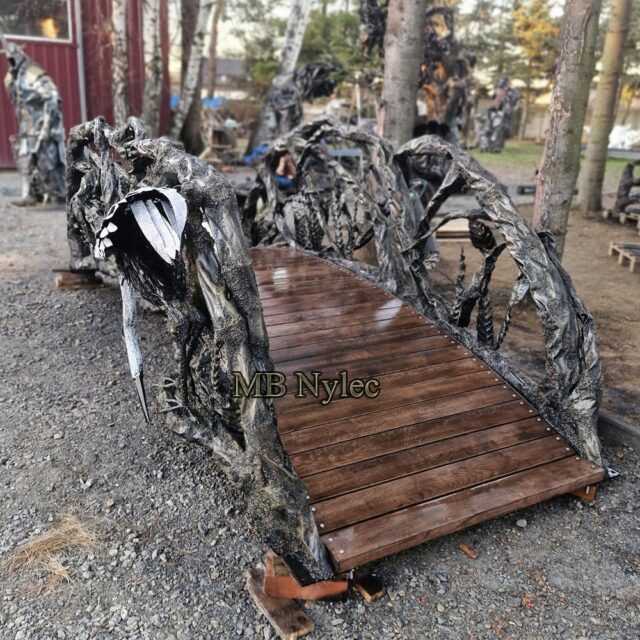 Forged garden bridge with a timber deck and branch railings