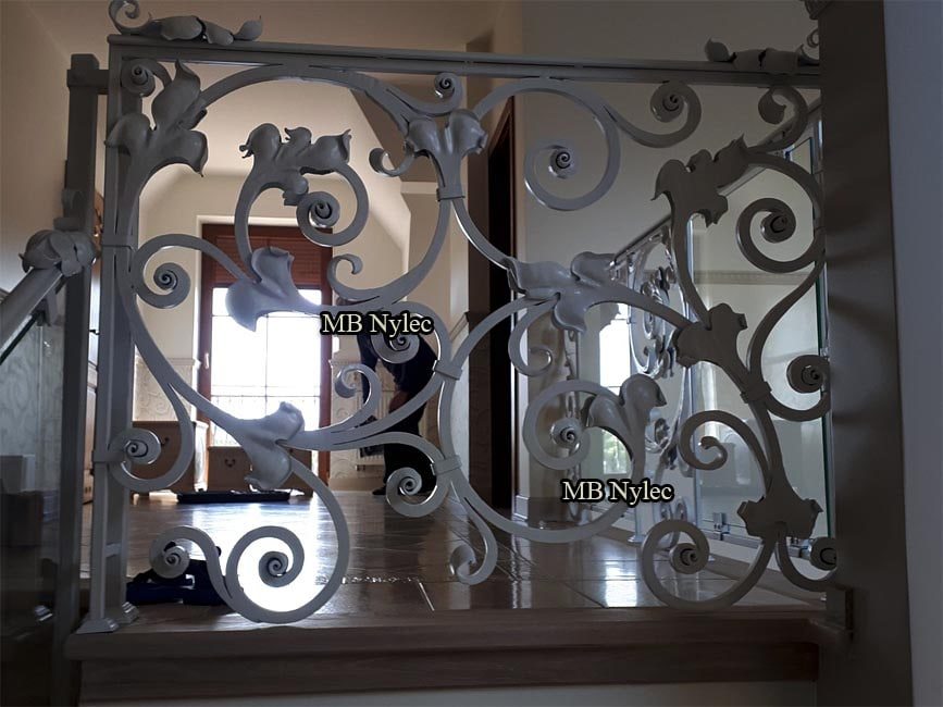 Forged leaf and scroll panel of balustrade BA68 next to a glass panel