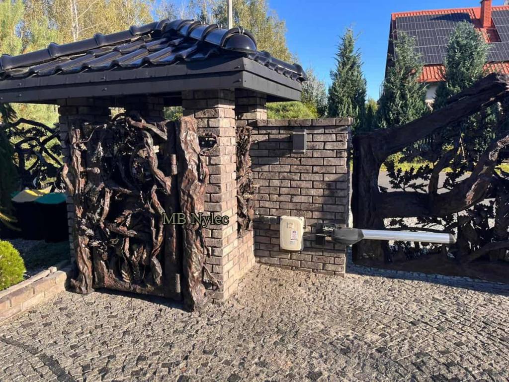 Forged metal gate of tangled branches on a bin enclosure
