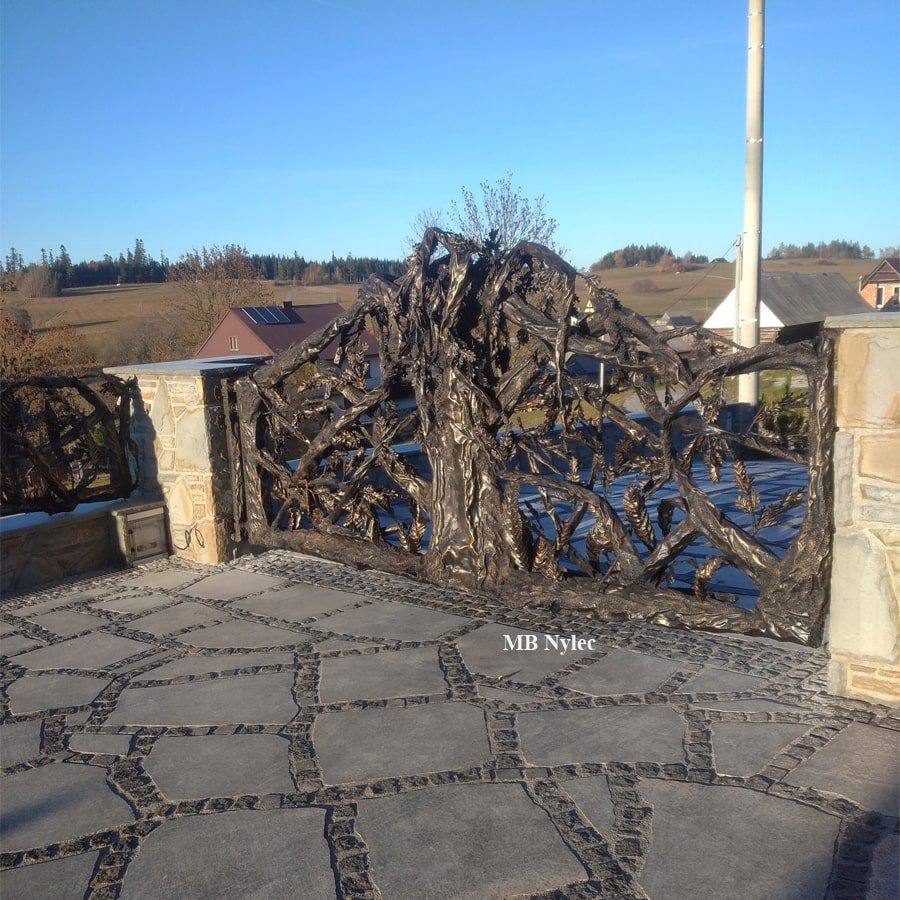 Close-up of a forged oak entrance gate with spreading steel branches