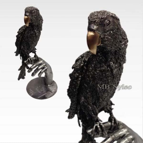 Hand-forged steel parrot with a golden beak perched on a steel hand on a round base