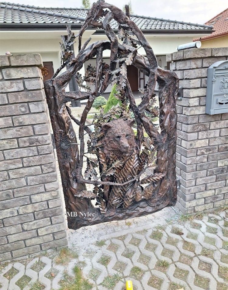 Forged tree and bear sculpture entrance wicket next to a mailbox