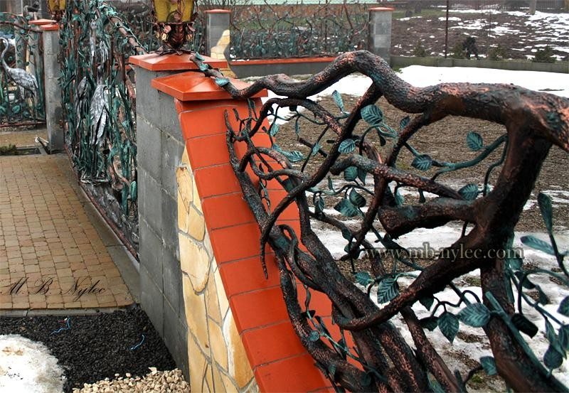 Forged tree fence BM6 with a thick trunk and leafy branches along a curved wall