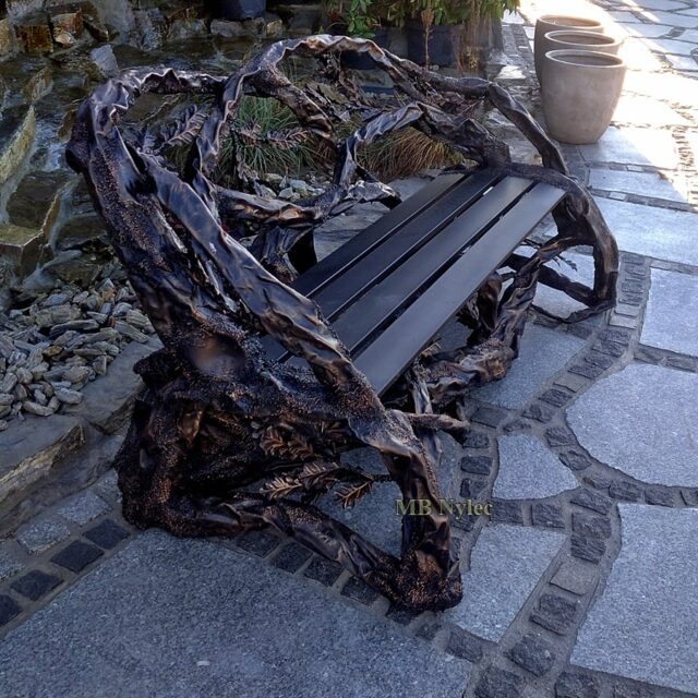 Forged garden bench made to look like tree limbs with dark timber slats