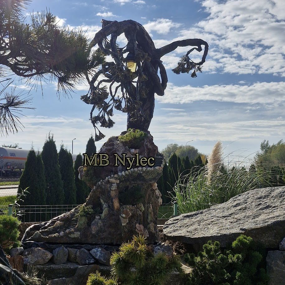 Forged tree sculpture with leaves rising from a rock base