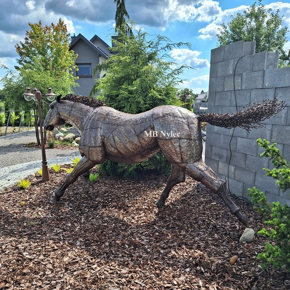 Galloping horse metal sculpture in a landscaped garden