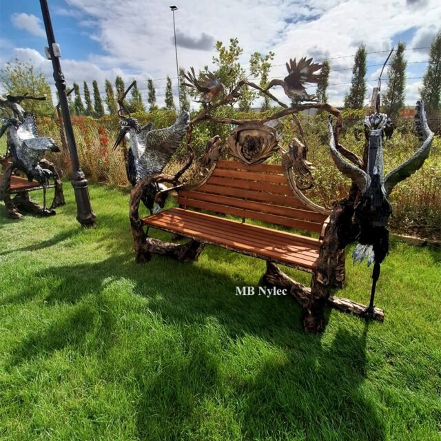 Garden bench with life-size steel herons on both sides and timber slats