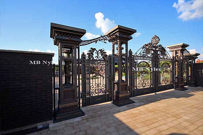 Side view of gate set BP56 with columns, wicket and gate against a brick wall