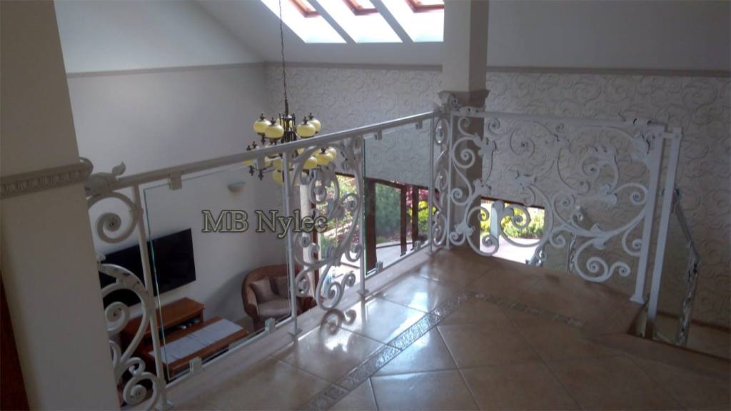 Mezzanine railing BA68 of glass and white forged ironwork above a living room