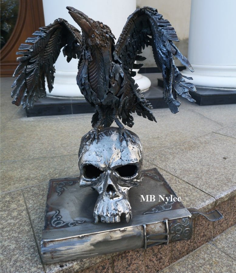 Gothic raven and skull metal sculpture by a white column