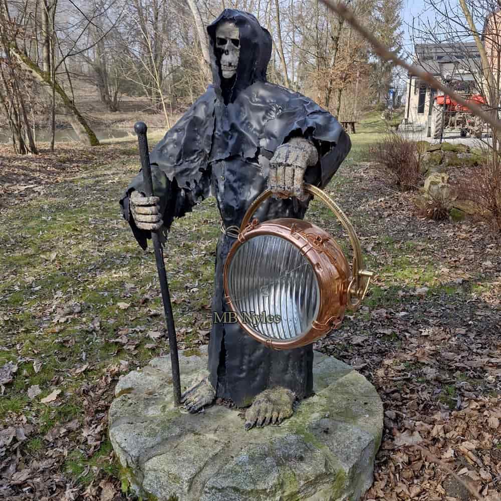 Steel sculpture of the Grim Reaper holding a copper ship's lantern