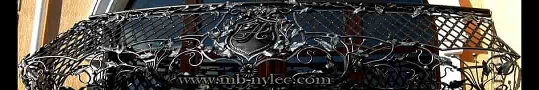 Curved wrought iron balcony railing with lattice, forged leaves and monogram