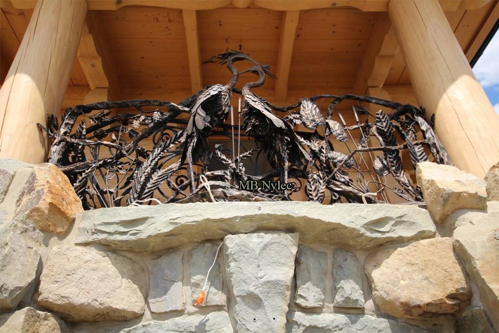 Balcony railing BA83 with a pair of forged herons among branches between log posts