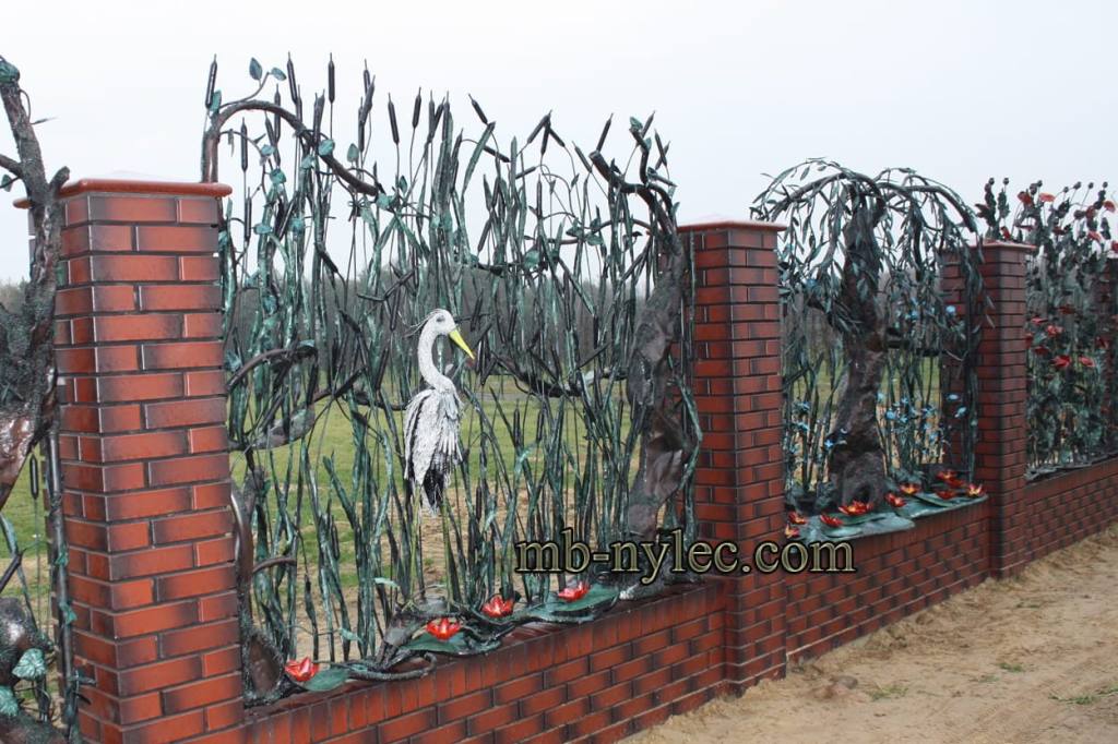 Forged fence span BM49 with a white heron among reeds and bulrushes between brick pillars