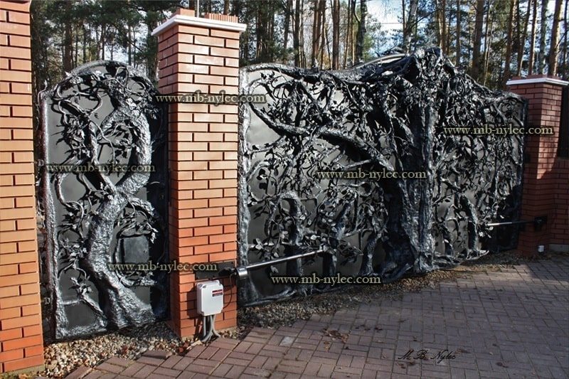 Hunting gate BM24 between brick pillars in front of a house among pines
