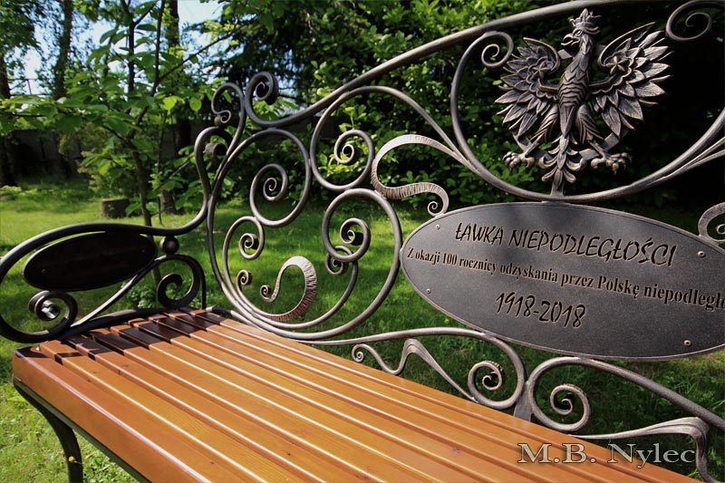 Oval plaque marked 1918–2018 beneath a forged eagle on Independence bench MK1C