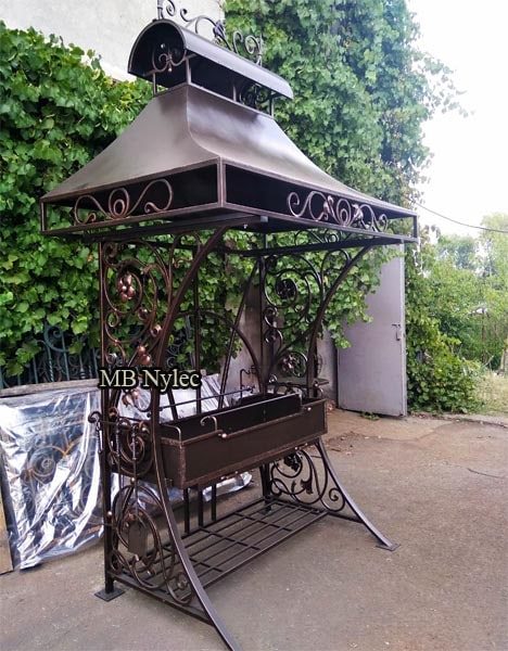 Large forged grill AG8 with a pagoda-like roof standing in a garden