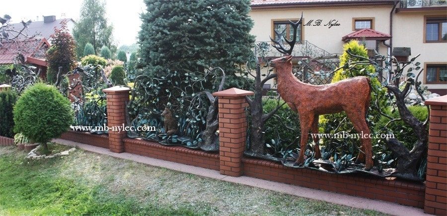 Life-size forged stag in the hunting fence BM16 between brick pillars