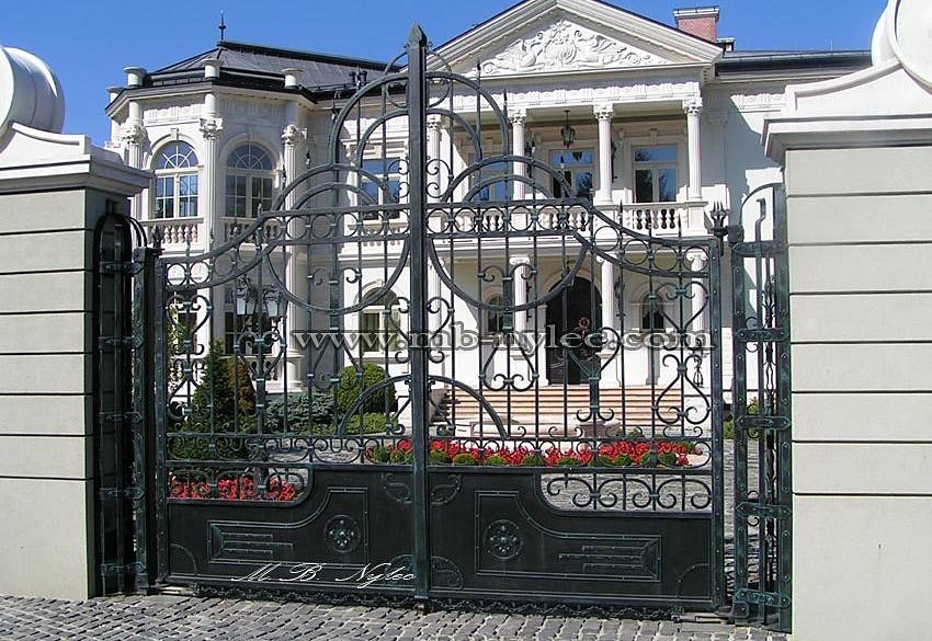 Manor gate BP29 with dense scrolls in front of a classical white residence