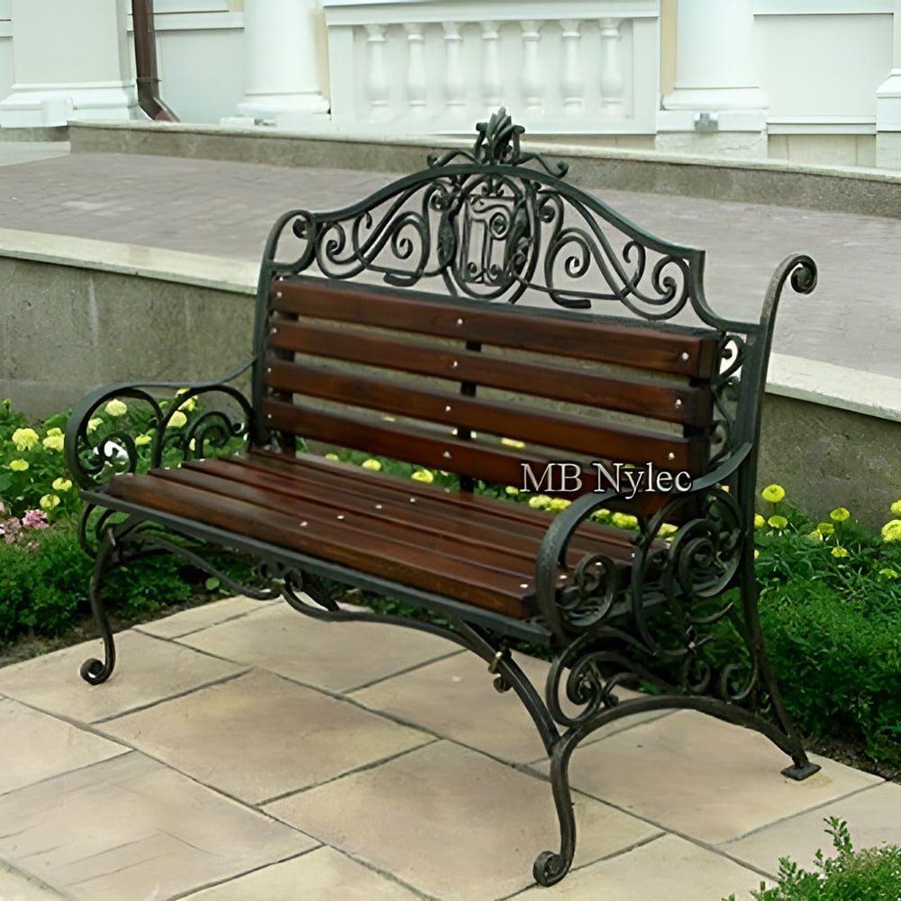 Manor-style forged bench MK7 with a crested backrest on a stone terrace