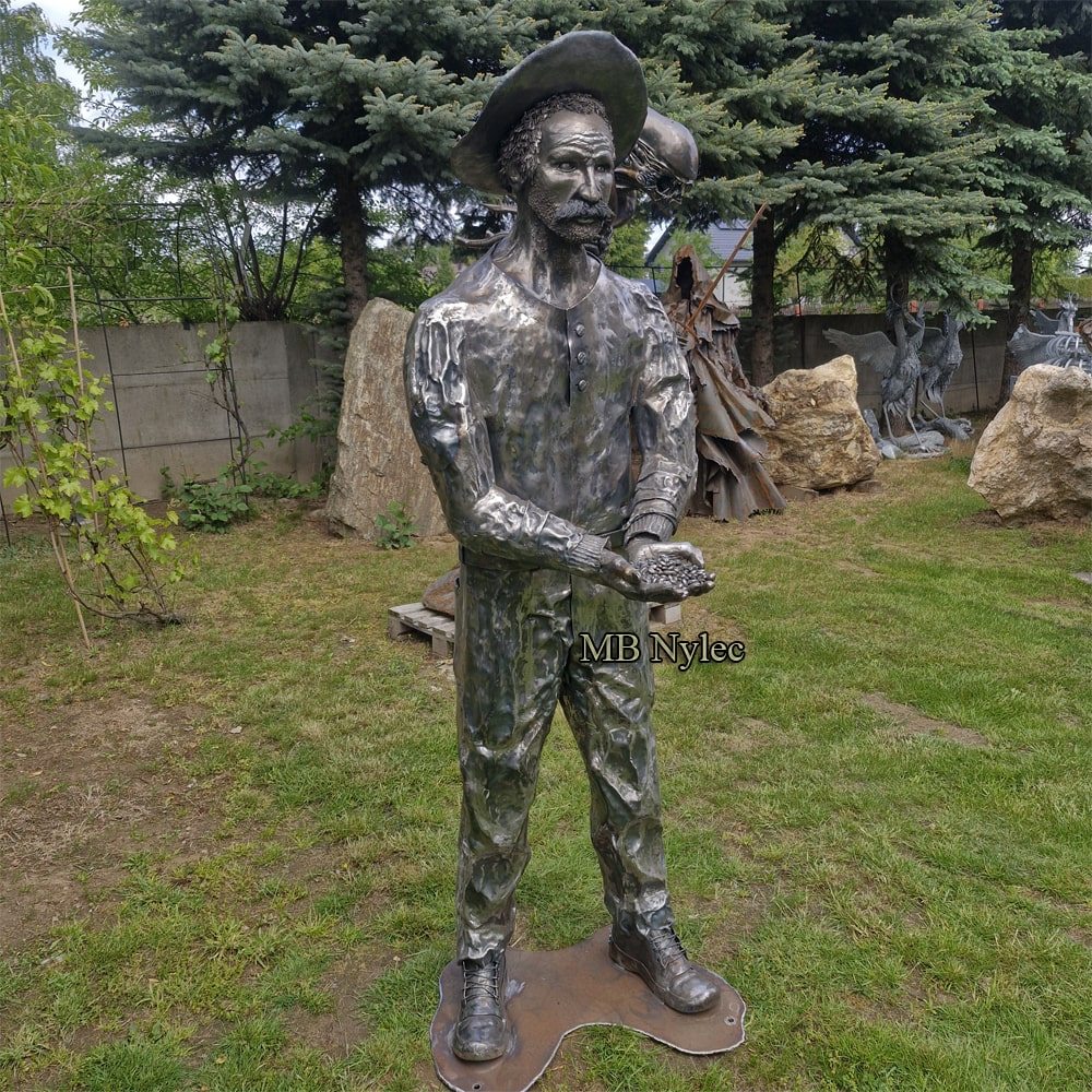 Metal farmer sculpture standing in a garden