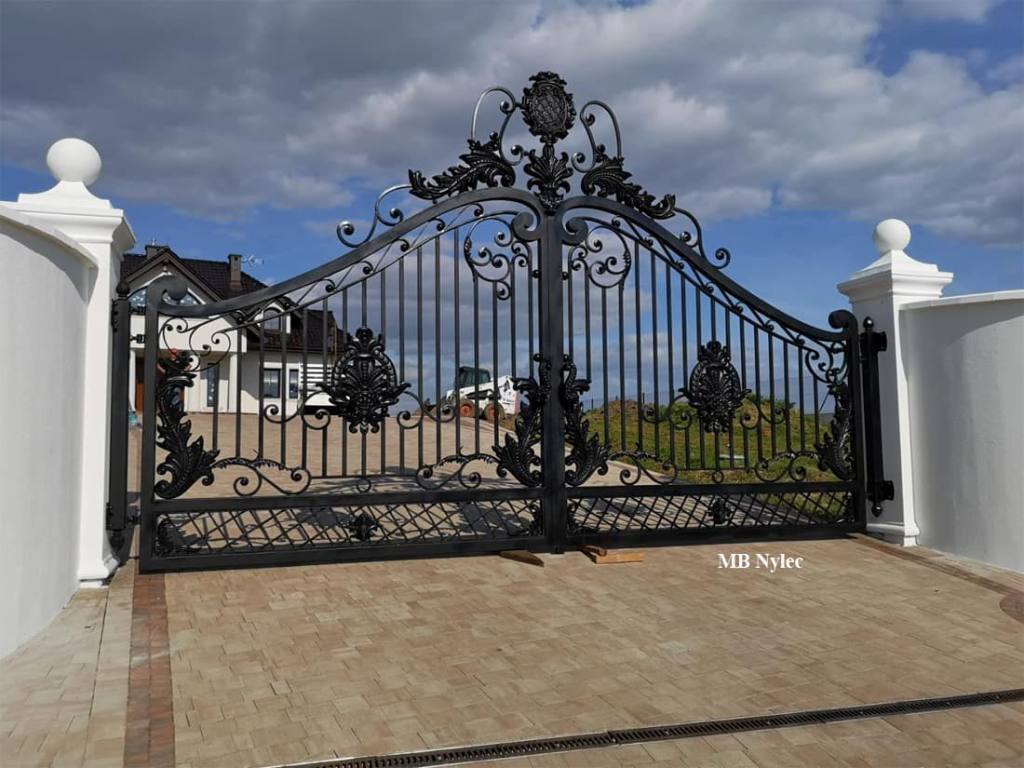 Metal gate about 6 m wide across a paved driveway